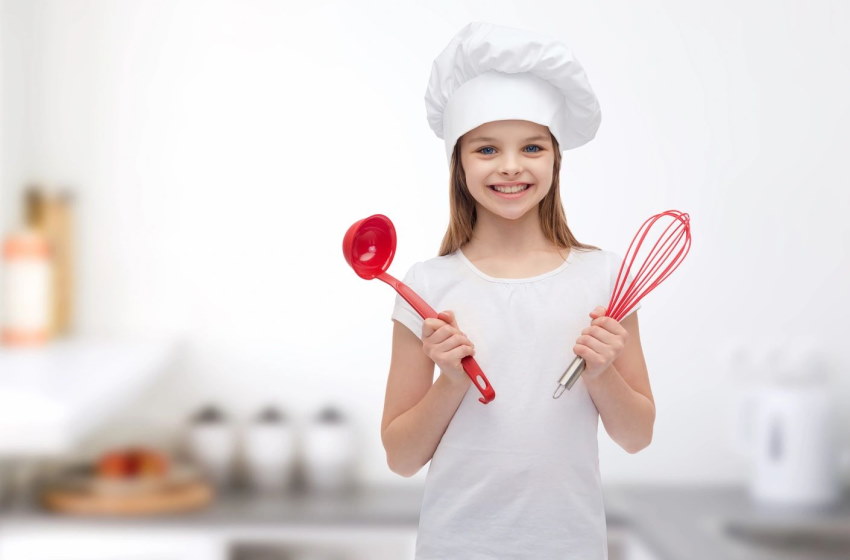 Image of a young lady chef with a whisk in one hand and a ladle in the other at a cooking class at 