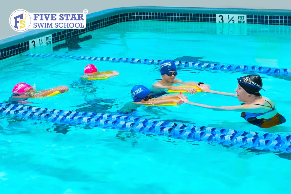 Kids swimming in a pool at Five Star Swim School in New Jersey
