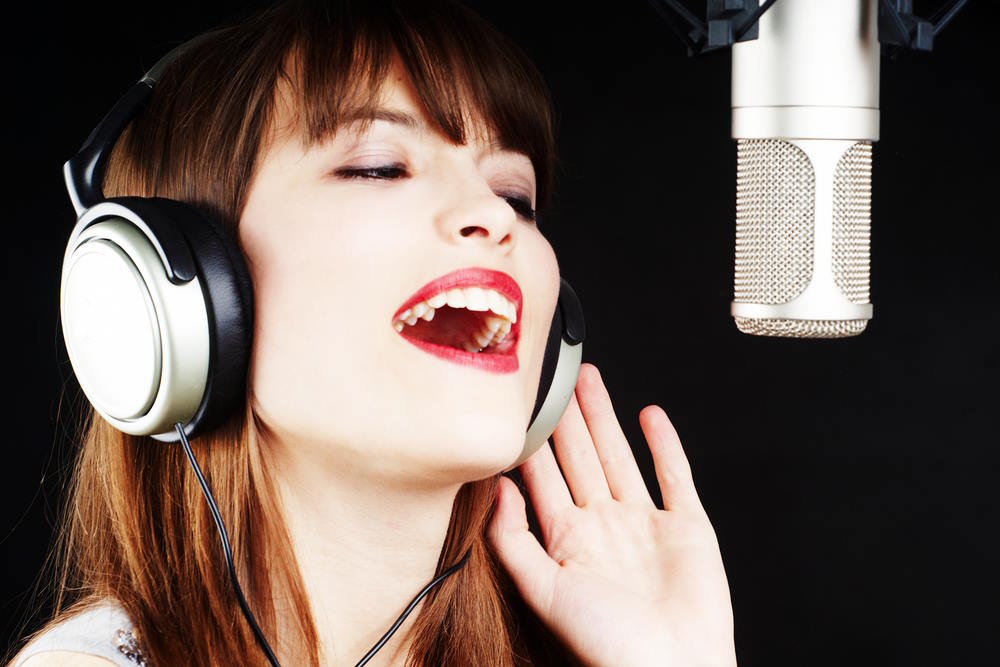 Image of a girl from New Jersey singing in a microphone in her free time at home