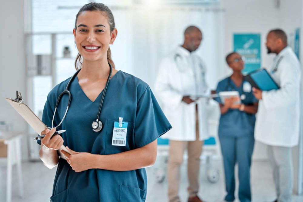 Image of a nurse forefront with three doctors and nurses in the background.