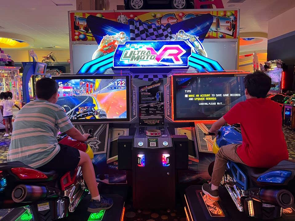 Image of two children riding on motorcycles on an arcade game at iplay America.