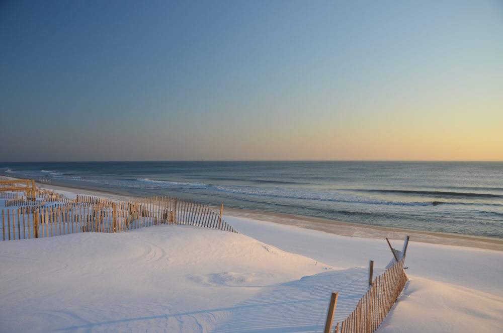 Image of a snow covered beach and dunes at sunrise down the Jersey Shore