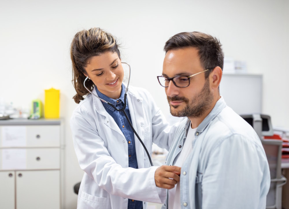 Image of a doctor checking a man's heart beat with her stethoscope