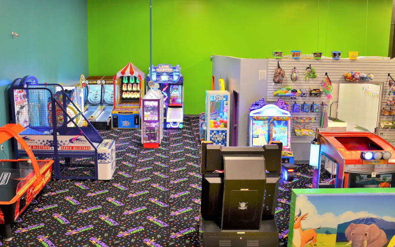 Photo of Bounce About's play room in Toms River Nj with arcade machines and stylized carpet