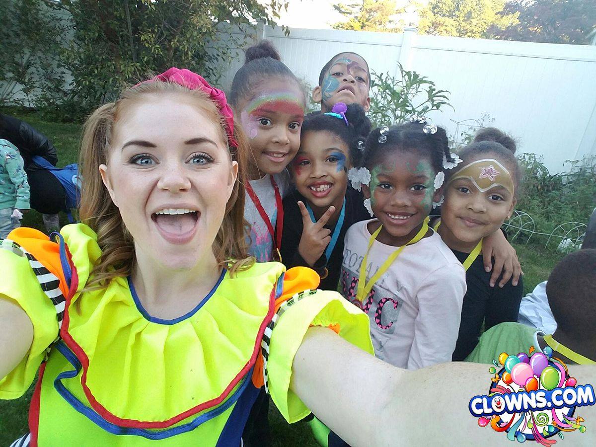 Girl clown with a yellow dress on entertaining 5 children in the back yard 