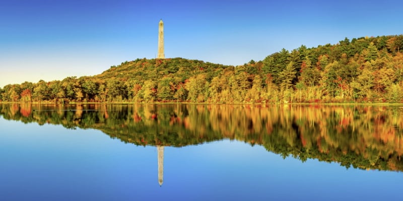 Image of the lake and autumn trees in the background reflecting in the water at High Point State Park as a fun place to bring kids in NJ