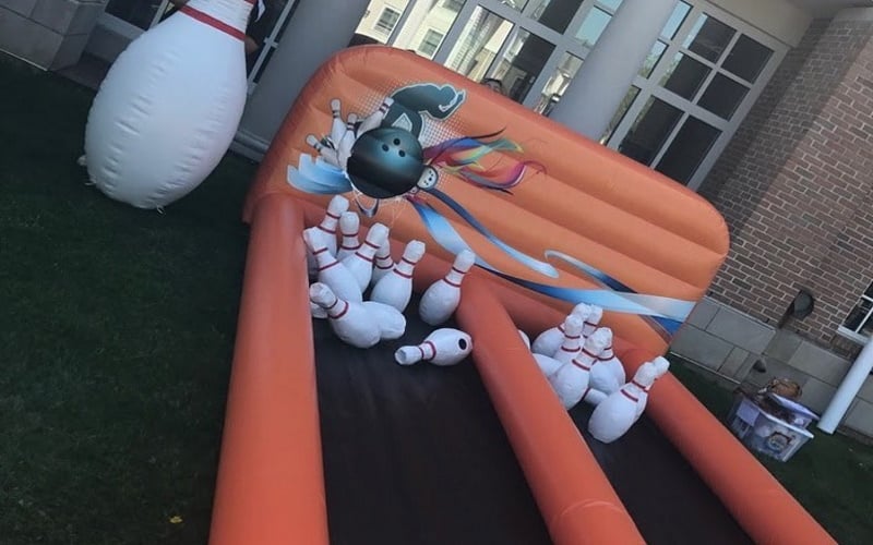 Image of a orange inflatable bowling game with two lanes and pins knocked down 