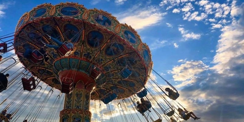 Photo a swing ride at the Point Pleasant Boardwalk in front of a clear blue sky with a few fluffy clouds