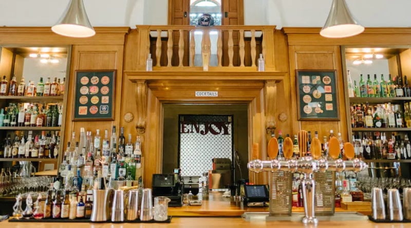 Image of the bar at Jockey Hollow Bar and Kitchen with various bottles of alcohol.=