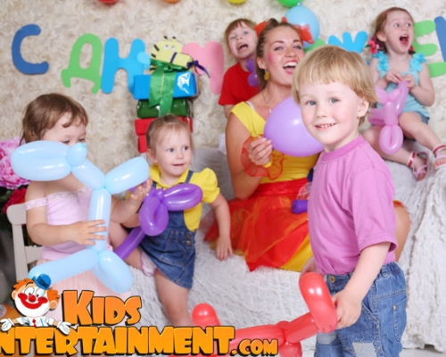 Image of a mother with 5 kids holding balloon animals at a childrens birthday party