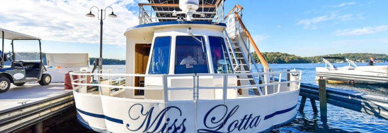 Image of the back side of the Miss Lotta on Lake Hopatocong NJ sitting at the dock ready to depart on a dinner cruise .