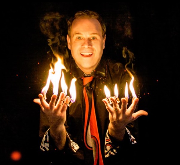 Image of a table with a black table cloth with magician props, a black magician hat and white gloves on it