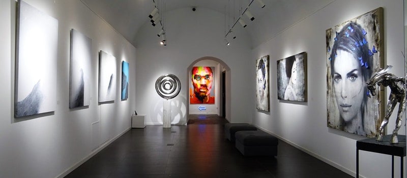 Photo of an art museum in NJ with 8 paintings on the wall and 3 sculptures 