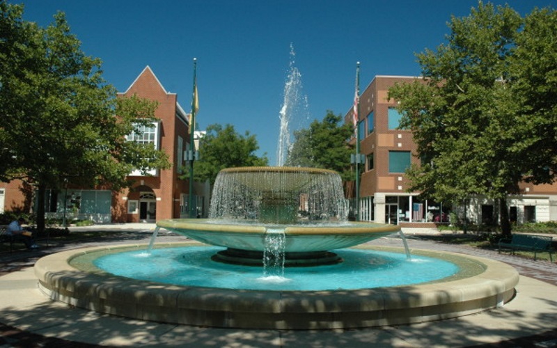 Photo of a fountain in the middle of the Princeton Forrestal Village in Mercer County NJ with red brick buildings in the back.