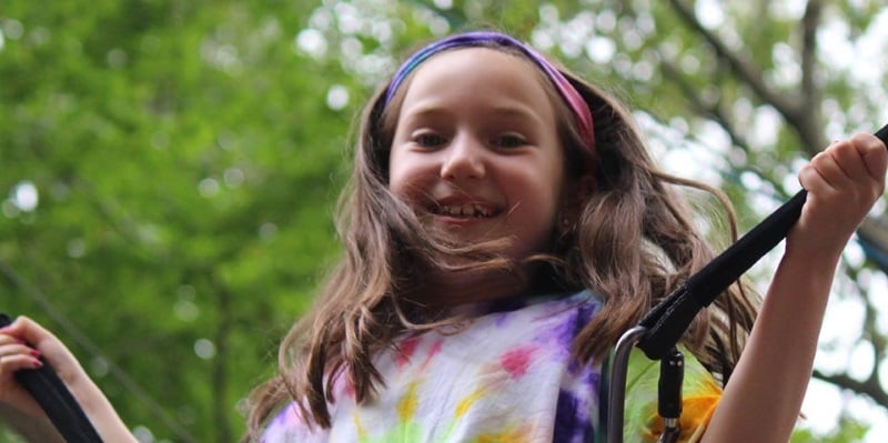 Image of a girl in a tye dye shirt on a trampoline at the Rolling Hills day camp in Freehold, NJ.