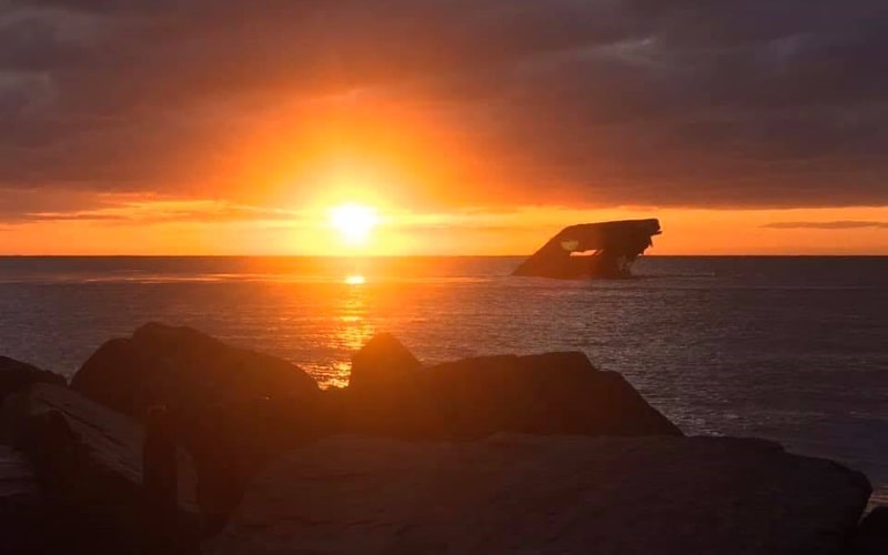 Photo of a sunset over calm waters that is reflecting a beautiful orange light at the Seashore Campsites in Cape May NJ