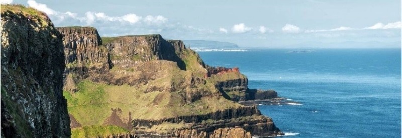 Image of tall cliff faces overlooking blue water in Ireland.