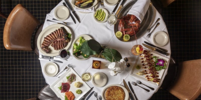 Image of a dinner table at the very romantic River Palm Terrace in Edgewater complete with their famous steak and seafood menu items.=