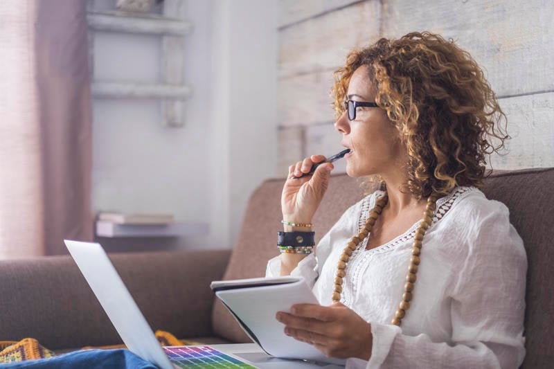 Image of a woman working on a college paper concentrating trying to manage her time wisely