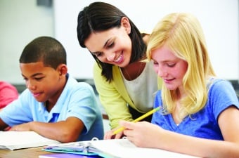 Image of two kids and a teacher doing written work showing tutoring as one of the ways for kids to learn in NJ