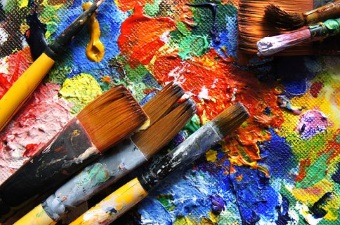 Image of paint brushes in multicolored paints showing art classes as a way to learn in NJ