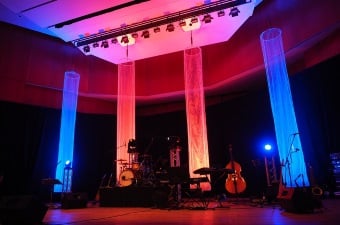 Image of a concert hall lit up with blue and pink lights where one may request party rentals in NJ