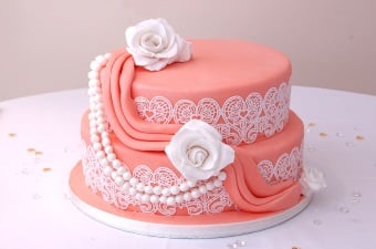 Image of a pink cake with lace design and roses detail showing the food party services available in NJ