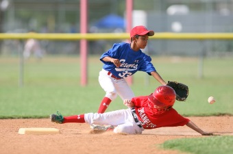 Image of two boys playing baseball with one running over the base as one of the sports centers in NJ