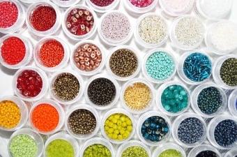 38 small white containers at a bead studio in NJ all with different cool colors of beads in them