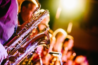 Image of someone playing a saxophone with a blues band at one of the best bars in NJ