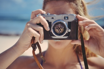 Image of a girl holding up a camera showing one of the best ways to explore NJ