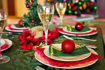 Image of red and green Christmas decorations and champagne on a dinner table showing holiday parties in NJ