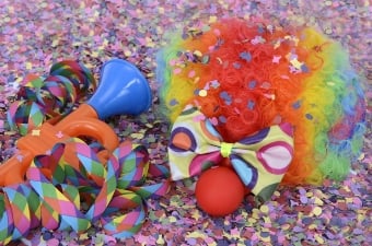 Image of a wig and clown nose laying in confetti showing a New York birthday party idea