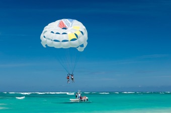 Image of two people parasailing over the ocean as an example of a cool date idea in NJ