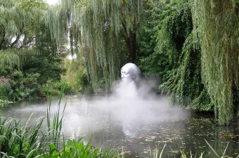 Image of a statue on water surrounded by mist and trees at Grounds for Sculpture at a fun NJ attraction