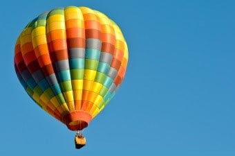 multi colored balloon flying in a beautiful blue sky