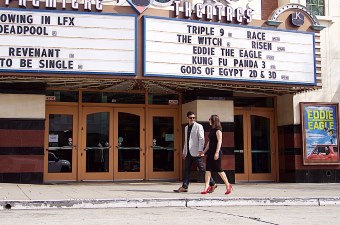 Image of a man and woman walking in front of a movie theater showing a fun thing to do in NJ