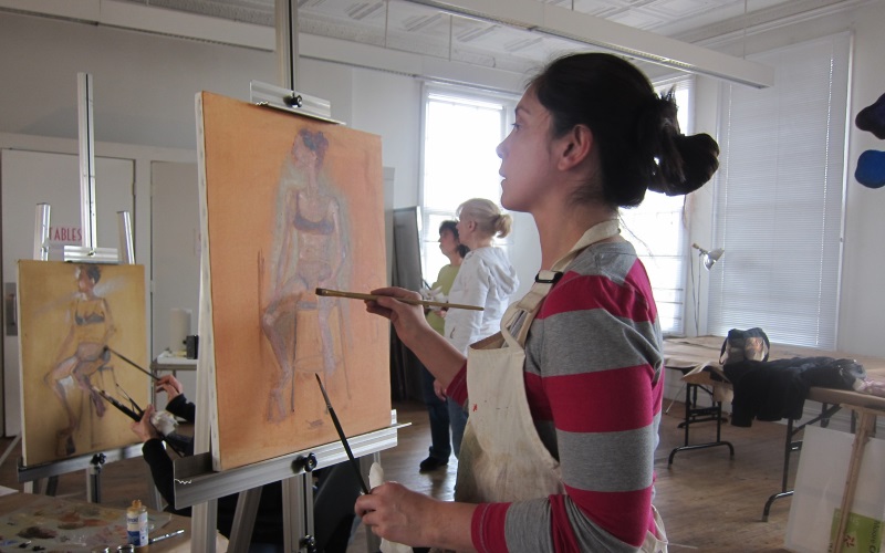 image of a woman painting a portrait of a woman on a canvas 